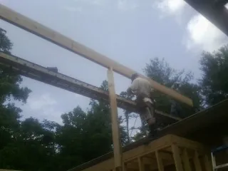 Carpenter setting a ridge beam over a new addition frame — Ice Dam Removal by Roofing Brothers in Seven Mile