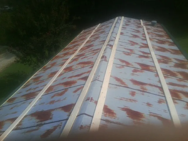 Rusted metal roof panels with new wood purlins before replacement — Storm Damage Roof Repair in Seven Mile by Roofing Brothers