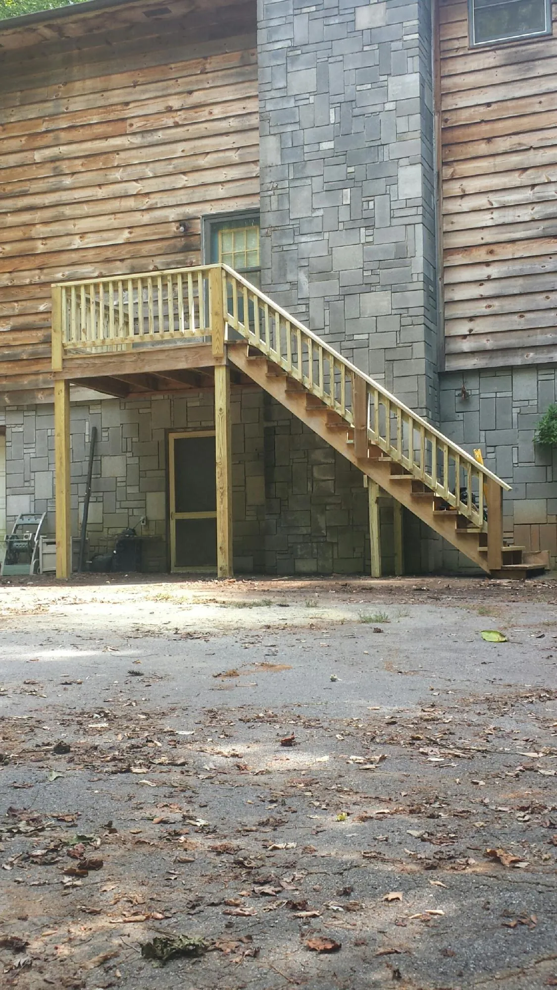 New pressure treated deck and stair landing on a log home in Seven Mile