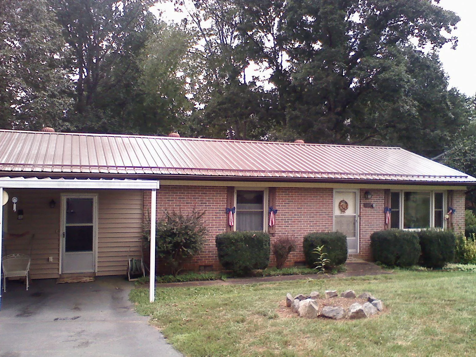 Bronze metal roof and carport on a brick ranch home — Roof Repair work by our crew in Seven Mile
