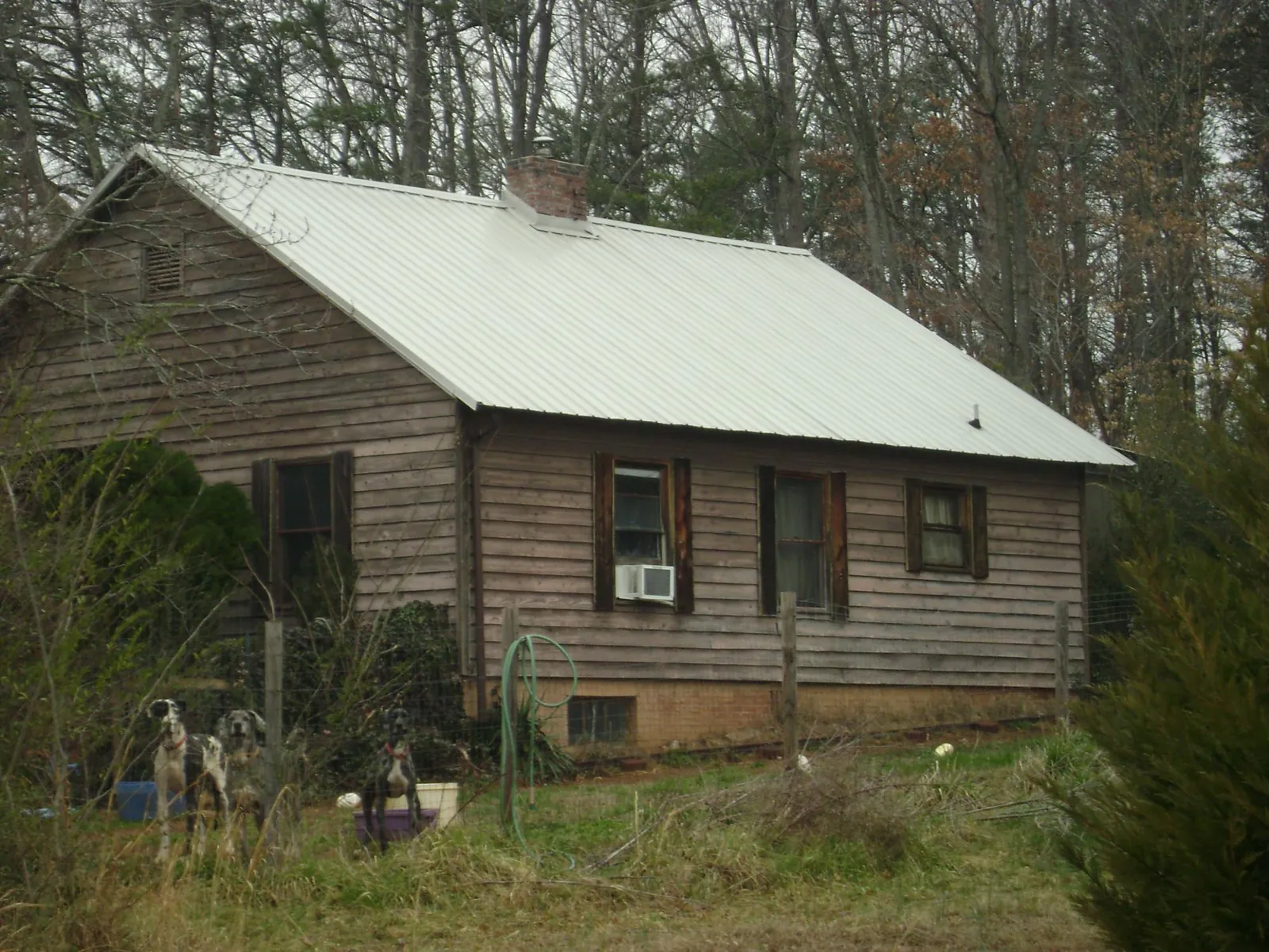 White metal roof on an old wood sided farmhouse, from a Metal Roof Installation job in Seven Mile